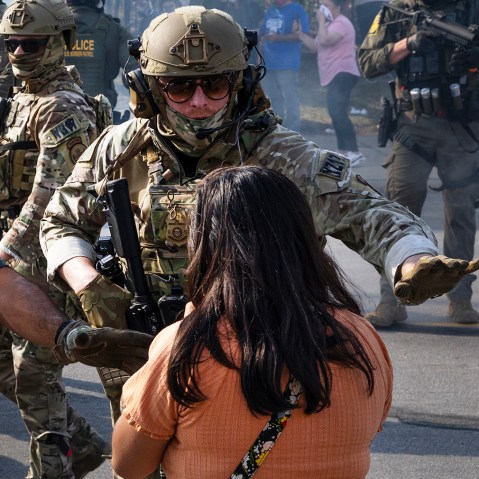 Police take two people into custody, as tear gas fills the air after it was used by federal law enforcement agents in Broadview, IL.
