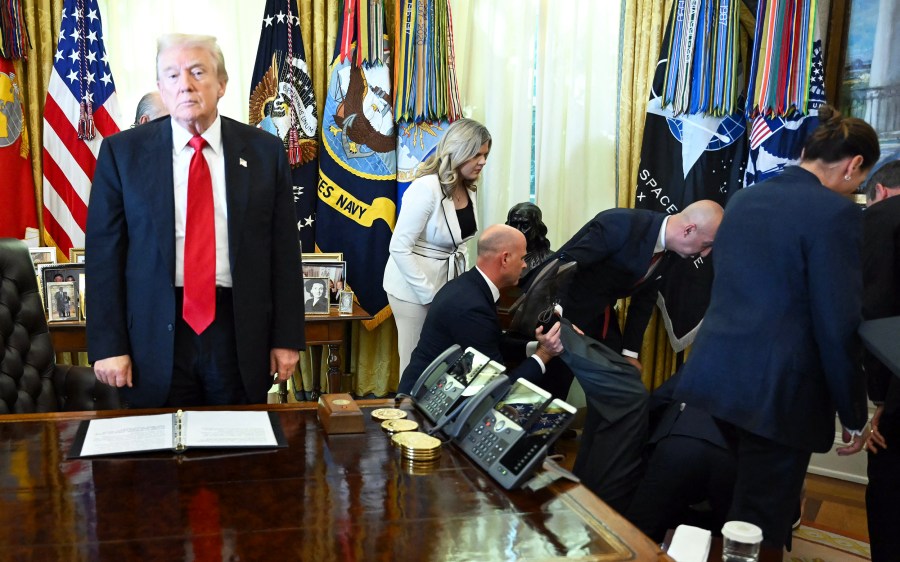 US President Donald Trump looks on after a man fainted during an announcement in the Oval Office.
