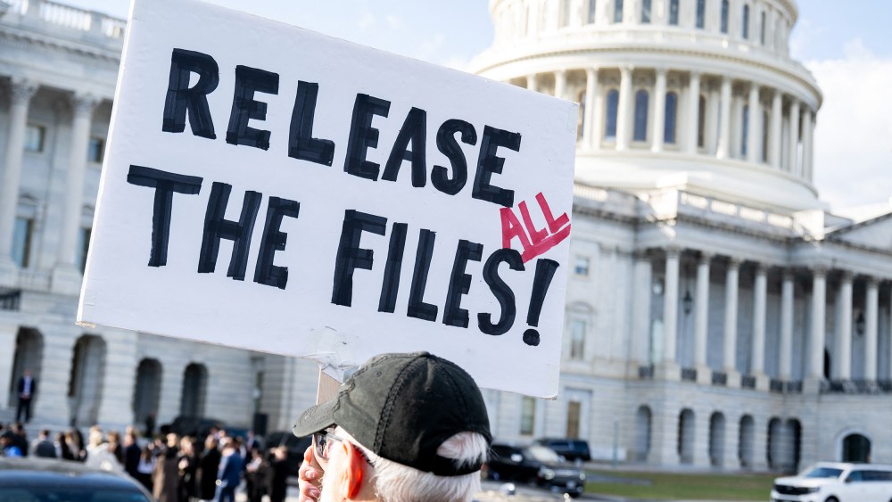 A protester holds a sign related to the release of the Jeffrey Epstein case files outside the Capitol.