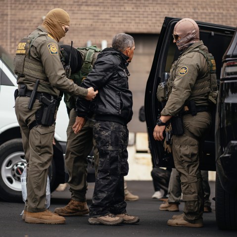 Immigration and Customs Enforcement agents take people they detained earlier to a parking lot before transferring them to an ICE facility in Chicago.