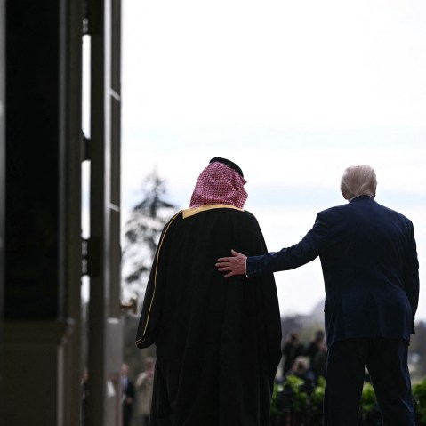 From behind, President Donald Trump greets Saudi Arabia's Crown Prince Mohammed bin Salman with a hand on his back, at the White House.