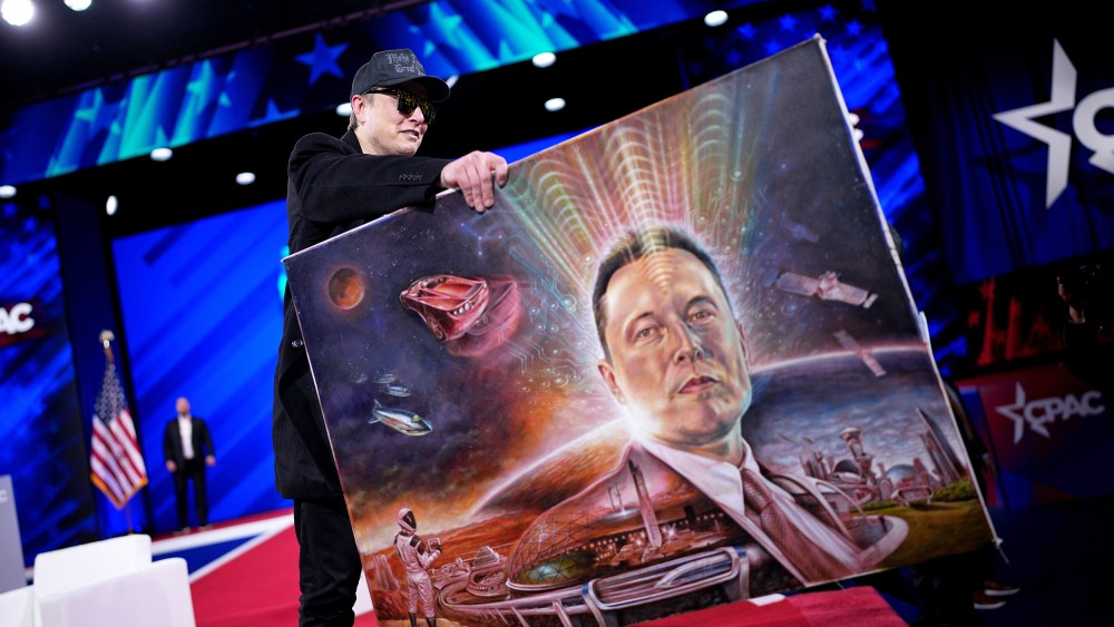 Elon Musk holds a painting of himself.