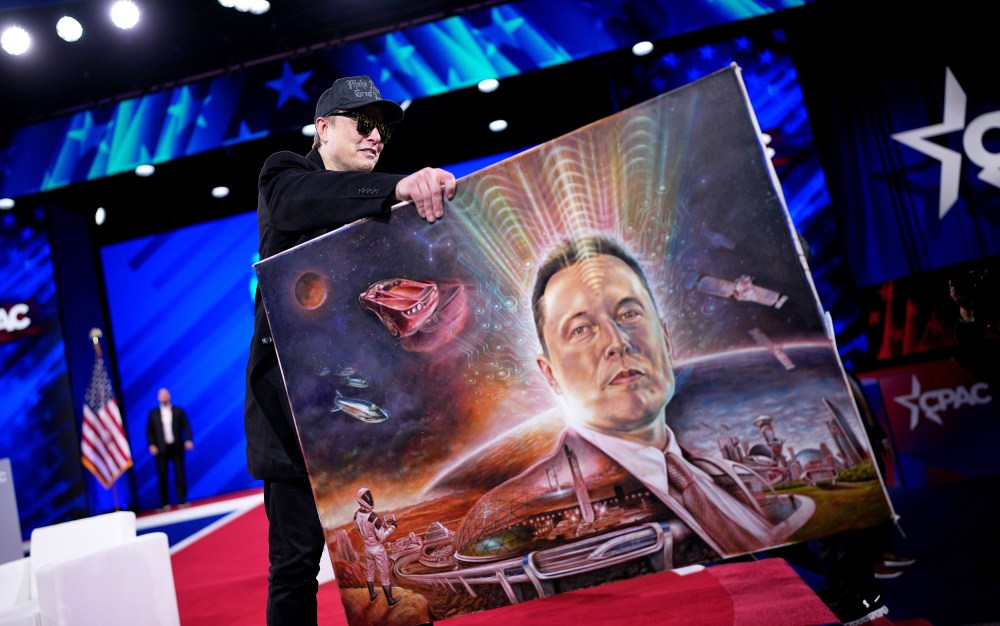Elon Musk holds a painting of himself.