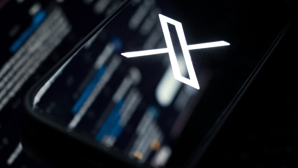 The web version of X mirrored onto a phone showing the X logo.