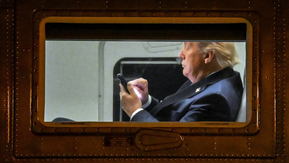 US President Donald Trump uses a cellphone aboard Marine One.