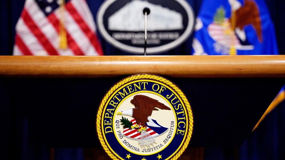 The Department of Justice seal and logo are displayed at the Department of Justice.
