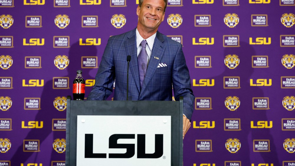 Lane Kiffin stands behind a podium at a press conference at Tiger Stadium in Baton Rouge, L.A.