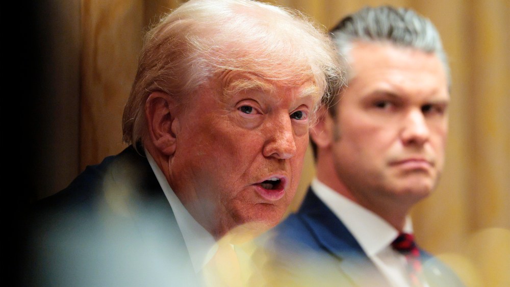 U.S. Secretary of War Pete Hegseth (R) looks on as U.S. President Donald Trump speaks during a meeting of his Cabinet.