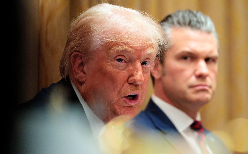 U.S. Secretary of War Pete Hegseth (R) looks on as U.S. President Donald Trump speaks during a meeting of his Cabinet.