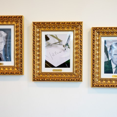 Framed portraits of President Donald Trump flank an image of former President Joe Biden's signature and an autopen along "The Presidential Walk of Fame" at the White House.