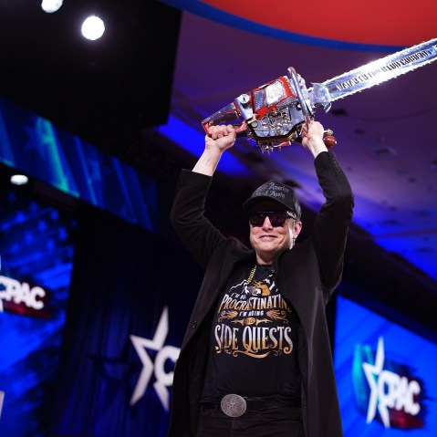Elon Musk leaves the stage holding a chainsaw after speaking at the Conservative Political Action Conference in Oxon Hill, M.D., on Feb. 20, 2025.