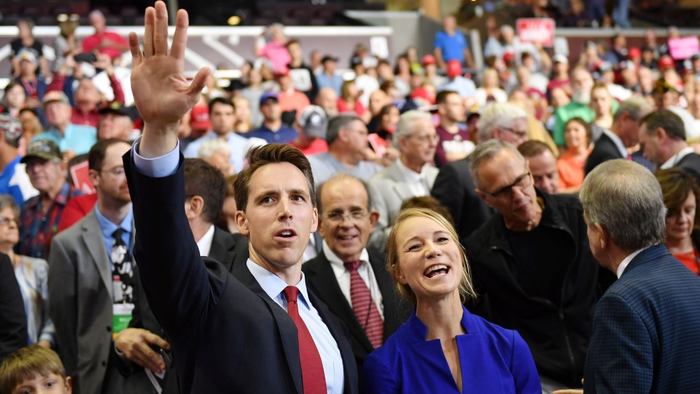 Then Missouri Attorney General Josh Hawley, left, and his wife Erin Morrow Hawley wave at a rally in Springfield, MO