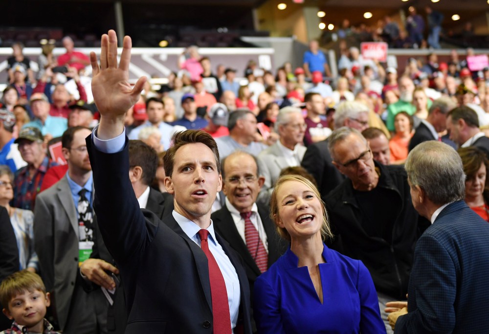 Then Missouri Attorney General Josh Hawley, left, and his wife Erin Morrow Hawley wave at a rally in Springfield, MO