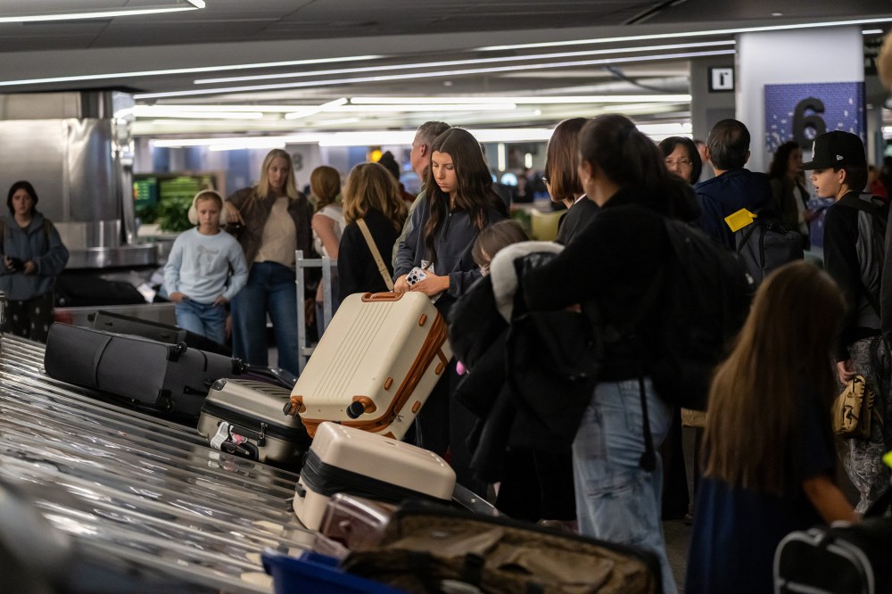 Travelers pick up luggage at a baggage carousel at San Francisco International Airport.