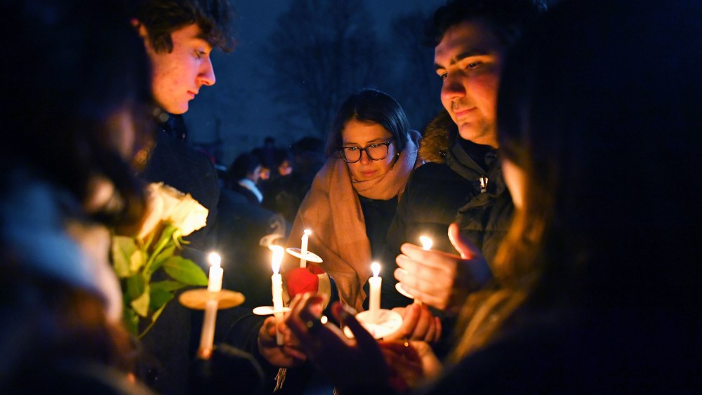 People hold candles during a vigil for those injured and killed during the Saturday shooting at Brown University.