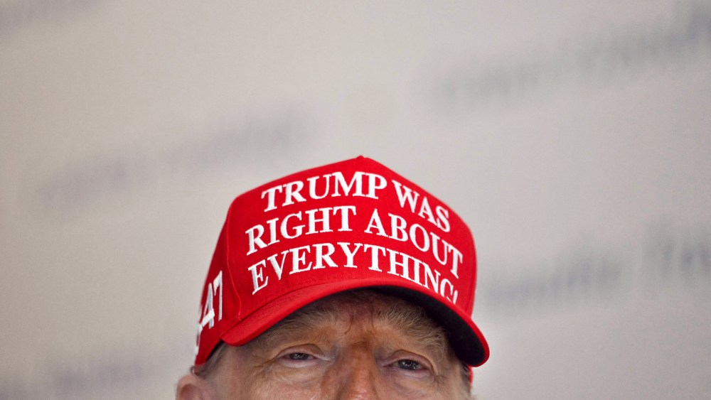 President Donald Trump wears a hat that reads "Trump was right about everything."