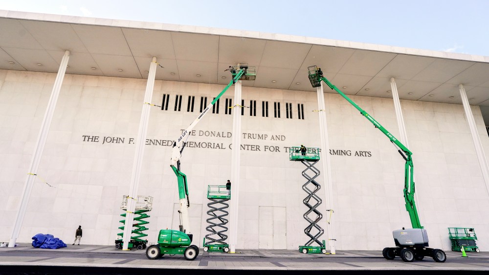 Workers affix signage adding US President Donald Trump's name on the facade of the Kennedy Center on Friday Dec. 19 in Washington, D.C.