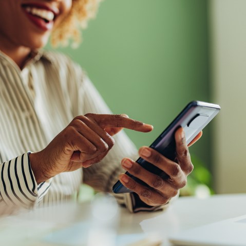 African American woman using social media on her phone.