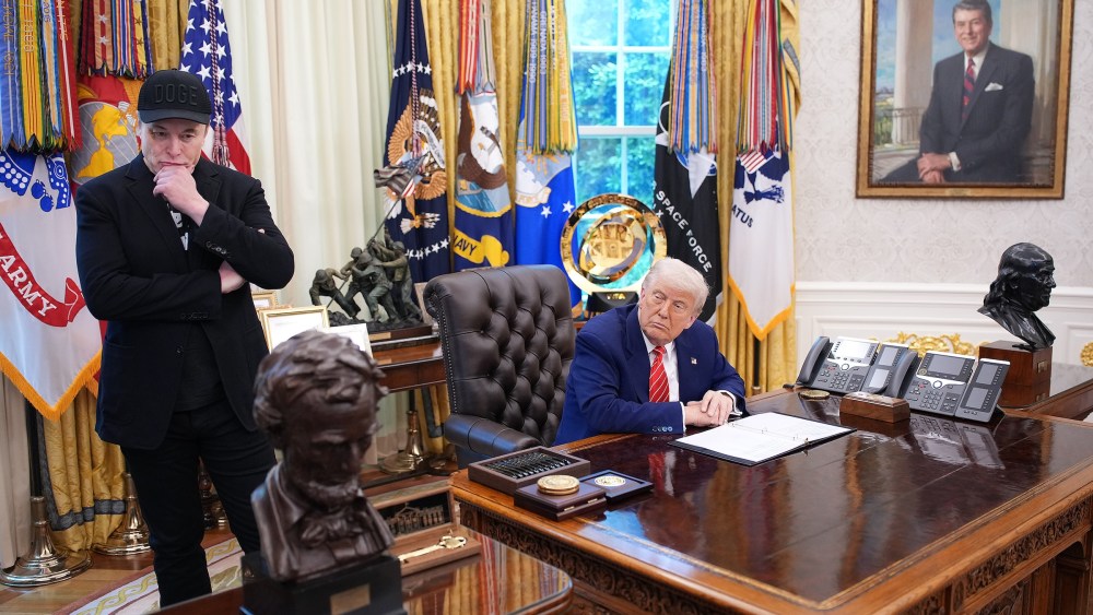 Tesla CEO Elon Musk and U.S. President Donald Trump listen to a question from reporters in the Oval Office.