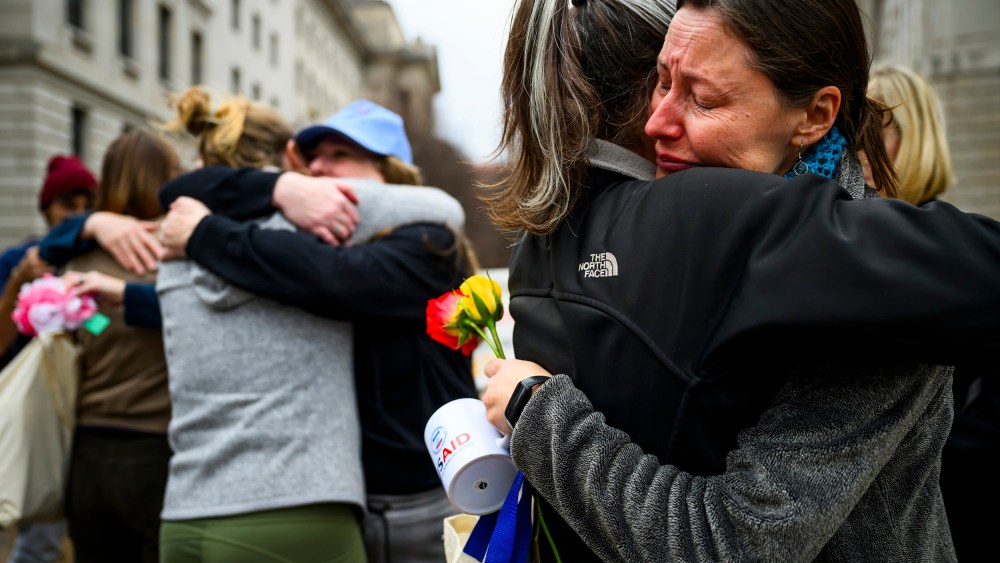 Prarie Summer, a USAID contractor for almost 10 years, right, cries as she embraces a Alexandra Jung after leaving the agency's former offices at the Ronald Reagan Building and International Trade Center.