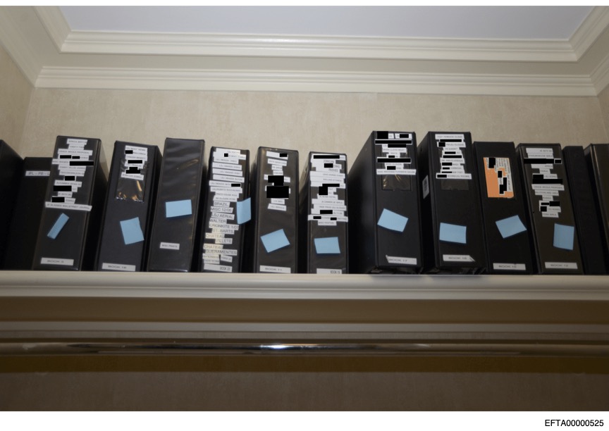 Albums with labels, some of which have been redacted by the Department of Justice.