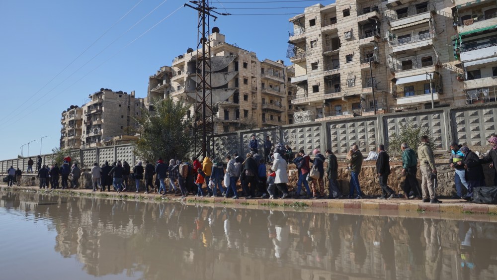 Civilians evacuate an area in Aleppo, Syria, Saturday, Jan. 10, 2026.