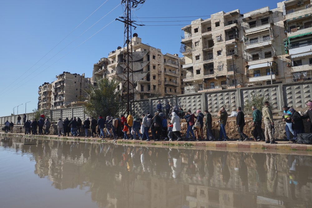Civilians evacuate an area in Aleppo, Syria, Saturday, Jan. 10, 2026.