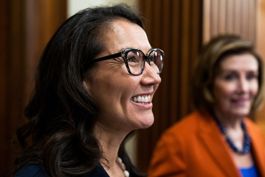 Mary Peltola smiles, with Nancy Pelosi in the background.