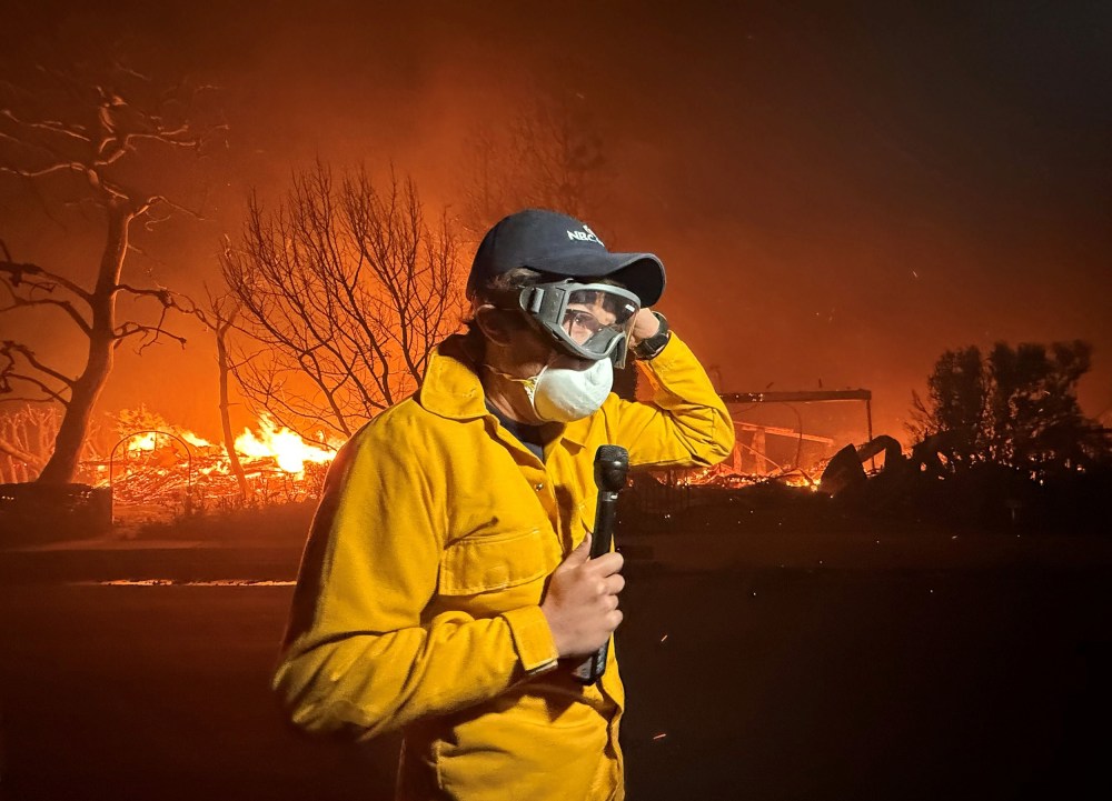 MS NOW's Jacob Soboroff stands with a microphone, wearing a face mask as Palisades fire continues in the background.