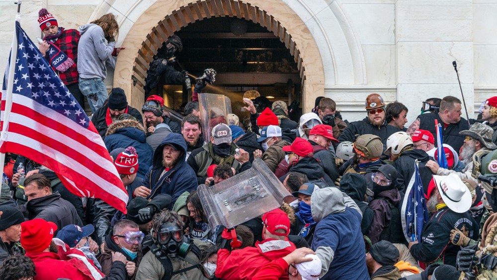 A police office sprays tear gas on a crowd of pro-Trump supporters attempting to enter the Capitol.