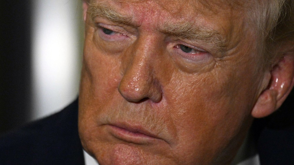A close-up photo of Present Trump's face while he talks to reporters on Air Force One.