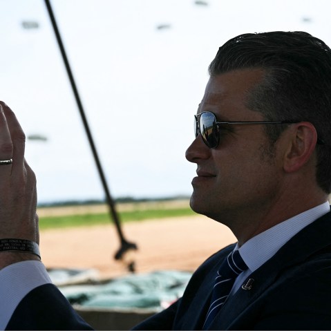 US Secretary of Defense Pete Hegseth holds up his phone to film during a military demonstration.