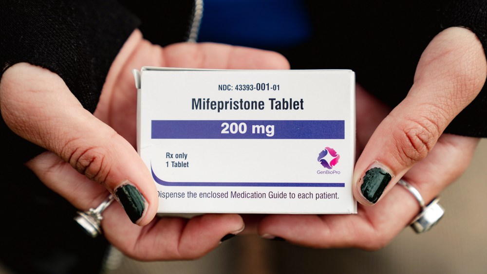 Trans man and abortion rights advocate Artemis Duffy holds a box of mifepristone on March 26, 2024 outside the U.S. Supreme Court.