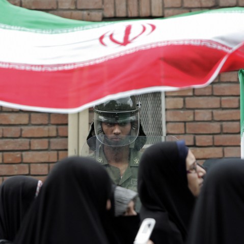 An Iranian riot policeman stands guard as demonstrators protest in Tehran.
