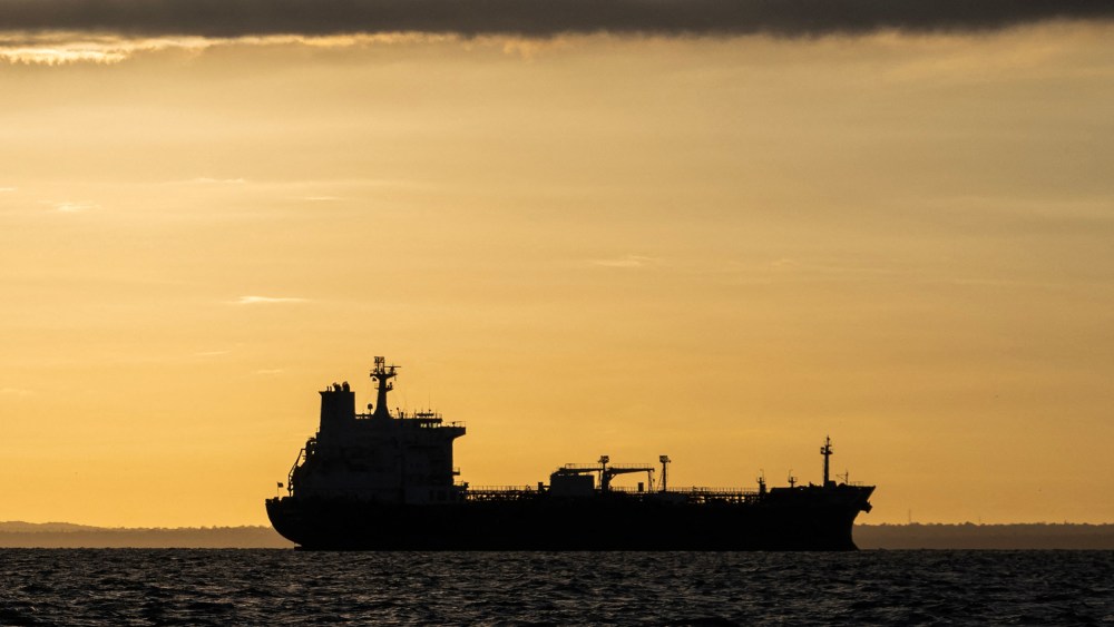 The silhouette of an oil tanker at sunrise.