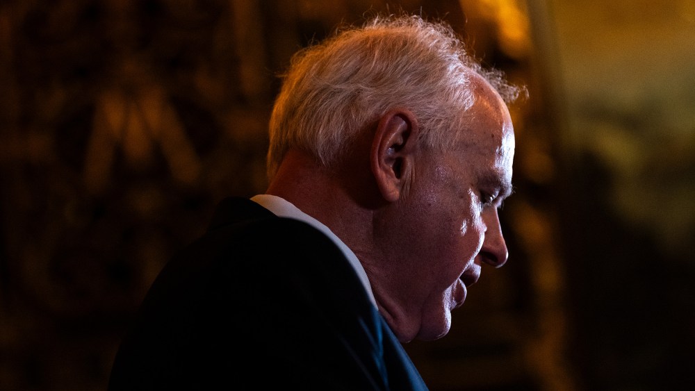 Tim Walz's profile, looking down.