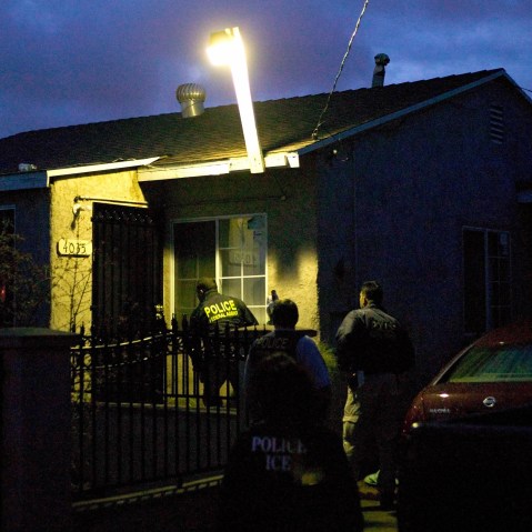 U.S. Immigration and Customs Enforcement agents in a predawn raid approach a house on March 7, 2006, in San Diego.
