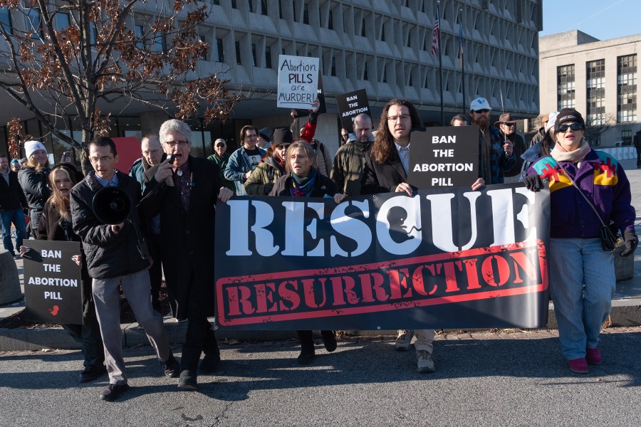 Rescue Resurrection group walks into the street with their sign for the sit-in protest. 