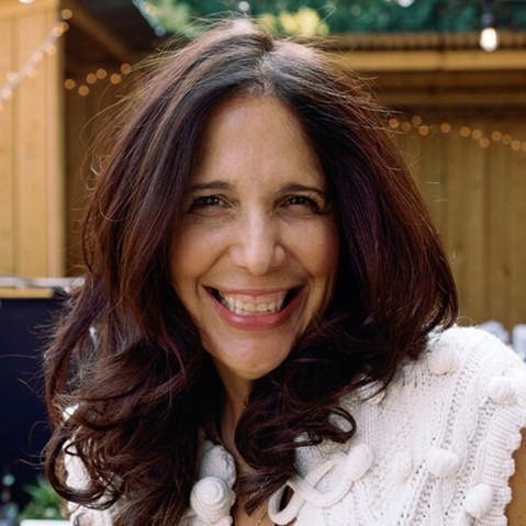 Sue Zarco Kramer smiles at an outside venue.