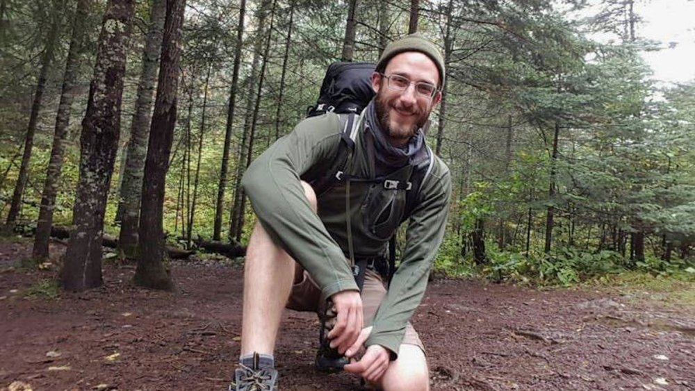 A selfie of a man backpacking in the woods