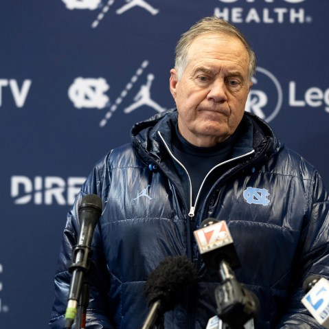 Bill Belichick looks down during a press conference.