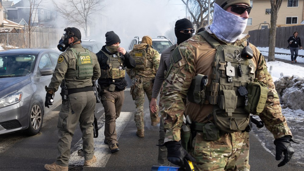Federal agents walk in the street.