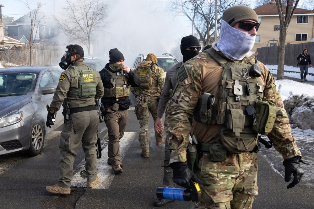 Federal agents walk in the street.