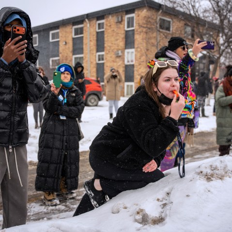 People use their phones to record and blow whistles in the snow.