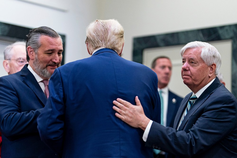 Senator Ted Cruz, left, greets Donald Trump, center, who is facing away from the camera. Lindsey Graham, right, pats Trump on the back.