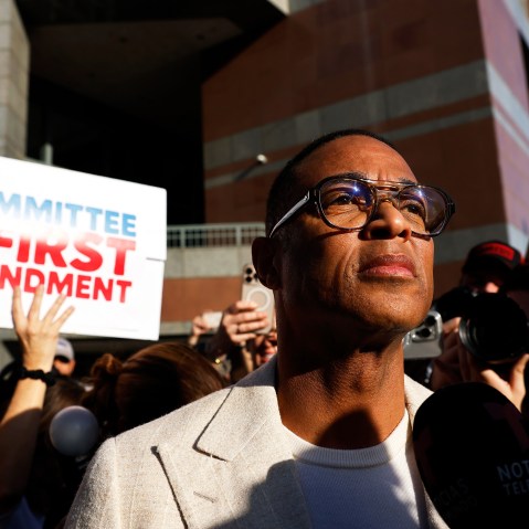 Don Lemon surrounded by people documenting with cameras and cell phones. A person behind him holds a sign that reads "Committee for the First Amendment."