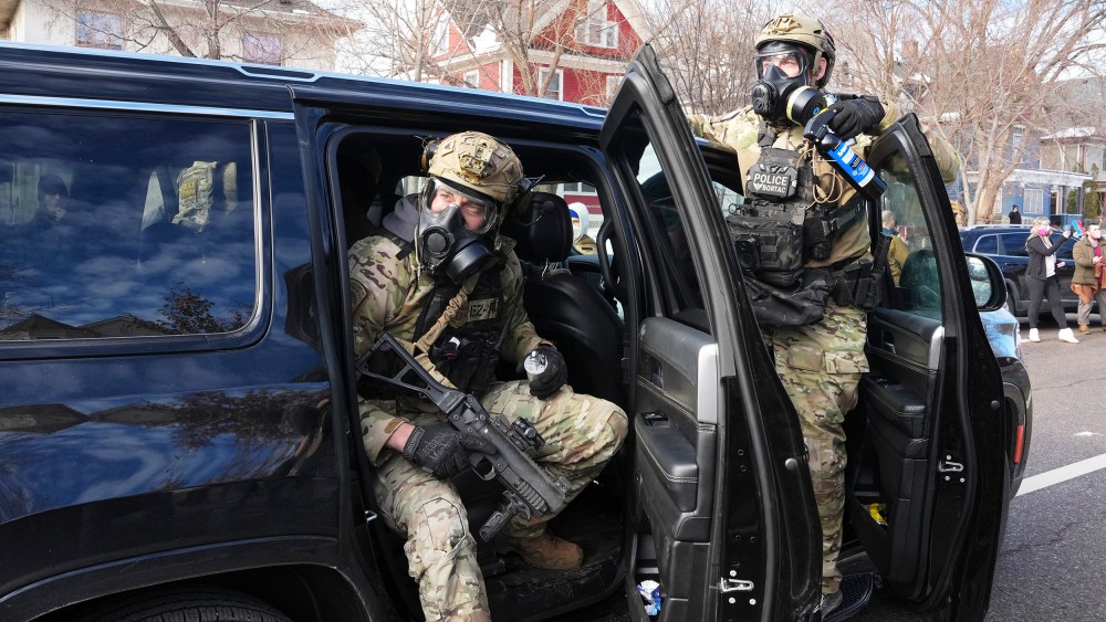Federal agents get ready to disperse tear gas into a crowd at a protest on Jan. 12, 2026 in Minneapolis.