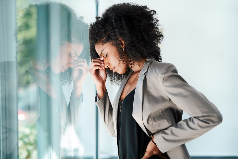 Shot of a young black businesswoman looking stressed out in an office.