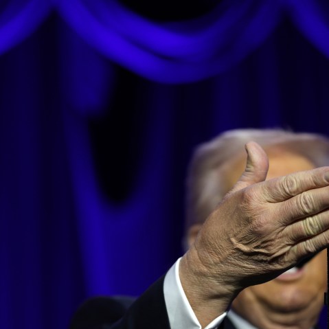 Donanld Trump's right hand obscures his face as he speaks at the National Prayer.
