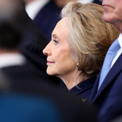Hillary Clinton is seen from the side among a crowd of people.